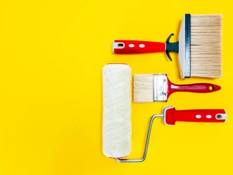 Professional house painter, work tools on yellow background Stock Photos