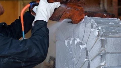 Professional ice carver making ice sculpture with electric chainsaw Stock Footage 128323019
