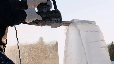 Professional ice carver making ice sculpture with electric chainsaw in Maryland Stock Footage 147354463