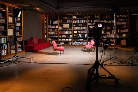 Professional indoor setup for a TV interview featuring cameras and cozy ch... Stock Photos