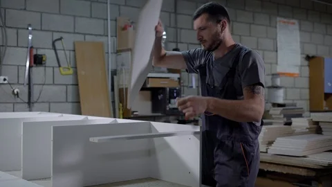Professional industrial worker in a uniform assembling a furniture in workshop. Stock-Footage 91194482