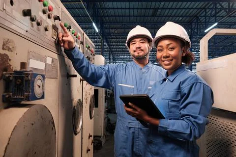 Professional industry engineers partner looking at camera and smile in factor Stock Photos