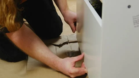 Professional installer secures panel of cabinet skillfully Stock Footage 304402745