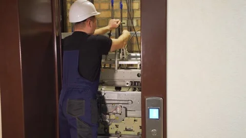 A professional installer, technical engineer prepares elevator equipment for Video stock 265258345