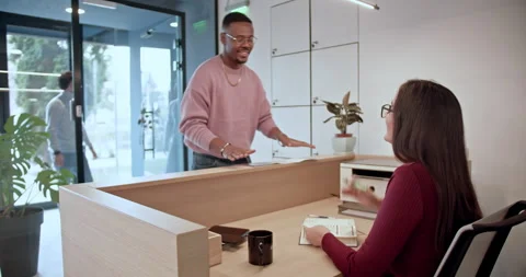 Professional interaction as guests check in at a hotel's reception, capturing Stock Footage 277306092