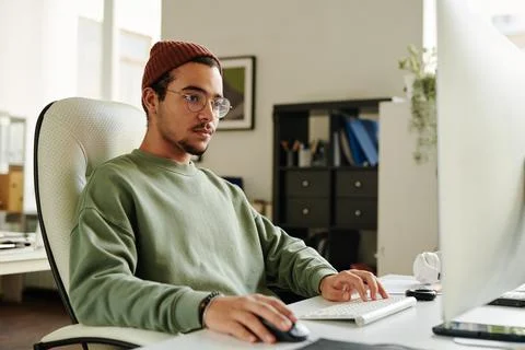Professional IT engineer in eyeglasses looking at computer screen Stock Photos