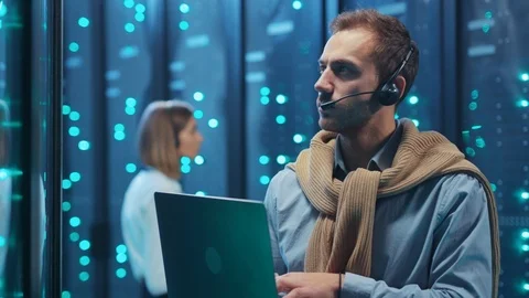 Professional IT specialist working on laptop diagnosing supercomputer typing on Stock Footage 119976980