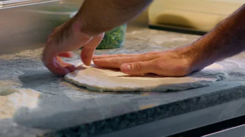 Professional italian restaurant chef working, shaping floured dough for pizza. Stock Footage 159337933