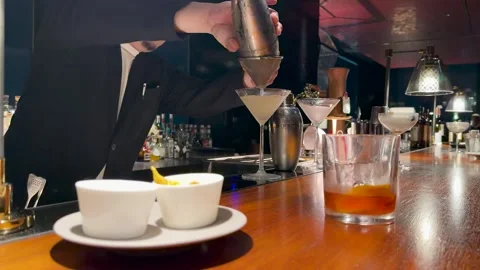 Professional Japanese Bartender Straining a Cocktail into a Martini Glass Stock Footage 334698039
