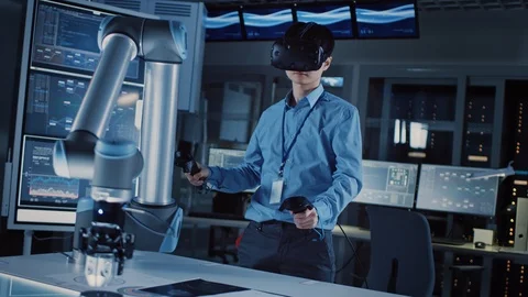 Professional Japanese Development Engineer Blue Shirt is Controlling Robotic Arm Stock Footage 105344480