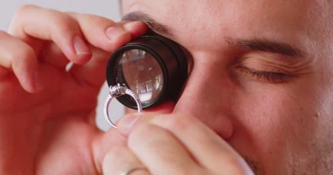 Professional jeweler during the evaluation of ring, looking through magnifying Stock Footage 311227699