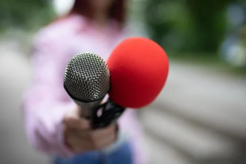 Professional journalist at work, writing notes, holding microphones Stock Photos