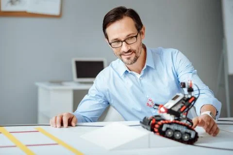 Professional joyful engineer testing the robot Foto stock