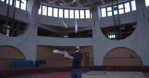 Professional juggler is practicing at the training session with white maces, 4k Stock Footage 147191595