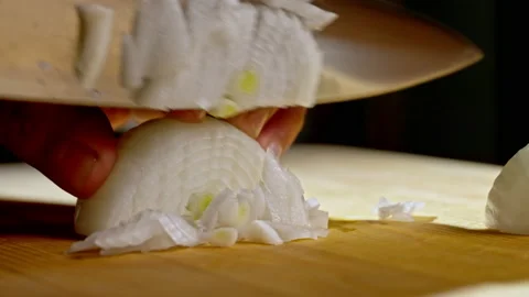 In a professional kitchen, a chef finely slices onions on a cutting surface Vídeos de archivo 232774974