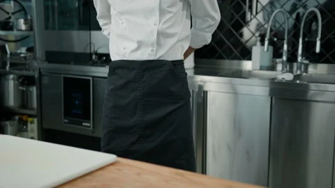 Professional kitchen chef putting on uniform tying apron before starting work Stock Footage 237976378