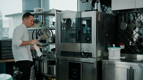 Professional kitchen the chef wipes the pan with a towel before cooking food Stock Footage 237976538