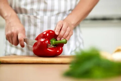 Professional kitchen hand slicing red bell pepper Stock Photos