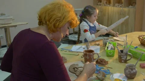 A Professional Lady is Painting Some Clay Toy With a Brush, While a Six Year Stock Footage 59128487