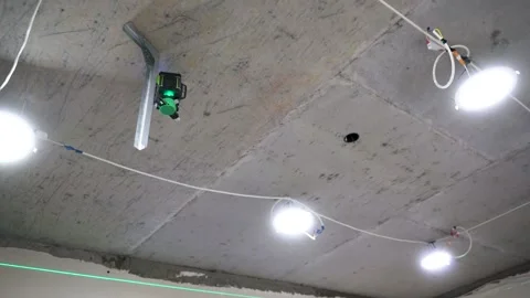 A professional laser level, set up on uneven concrete framed by the unfinished Stock Footage 309218225