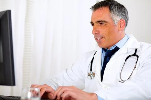 Professional latin doctor using a computer Stock Photos