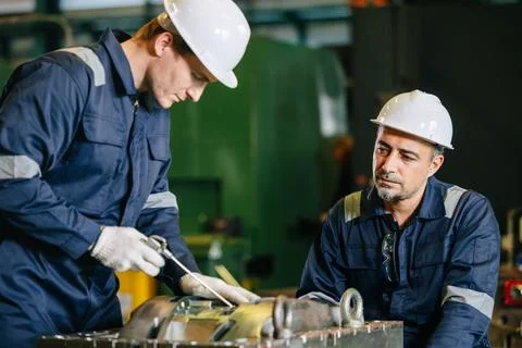 Professional lead engineer worker training young man to service injection m.. Stock Photos