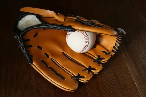Professional leather baseball ball and glove on wooden table Stock Photos
