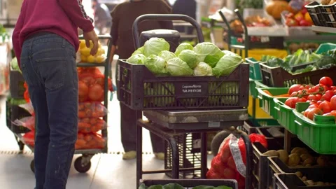 Professional Loader Carrying Large Crate With Raw Vegetables at Food Market Stockbeeldmateriaal 341548061