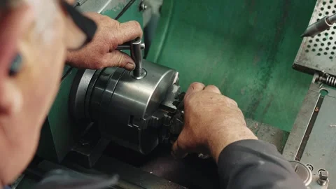 Professional locksmith is working at a lathe installs a part to be processed Stock Footage 284544229