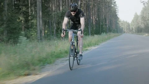 Professional long-distance cyclist training on an empty road Stock Footage 75399435
