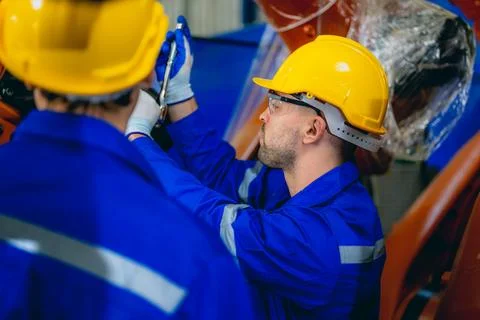 Professional maintenance worker with machine robotic arms at industrial factory 스톡 사진
