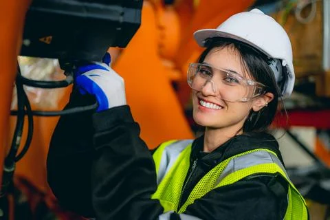 Professional maintenance worker with machine robotic arms at industrial factory Stock Photos