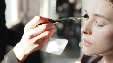 Professional make-up artist applying foundation with brush to skin of model Stock Footage 52265812