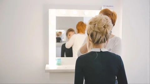 Professional make-up artist applying makeup on the face of the beautiful young Stock Footage 74458389