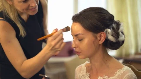 A professional make-up artist does make-up for the bride. The stylist works with Stock Footage 81254168