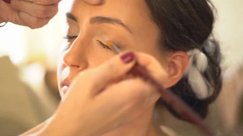 A professional make-up artist does make-up for the bride. The stylist works with Stock-Footage 81255095