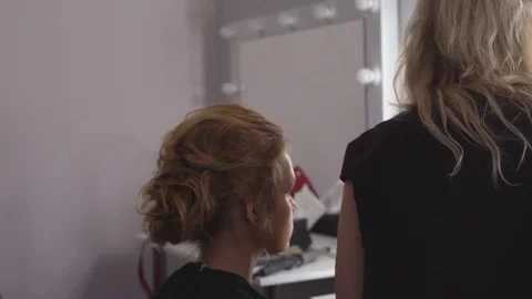 The professional make-up artist does make-up for the young cute model. two Stock Footage 83756068