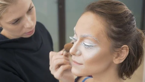 A professional make-up artist does the make-up of the model. Apply a special Stock Footage 83842348