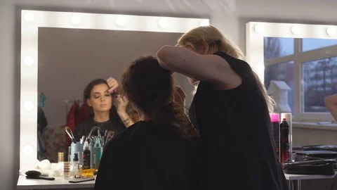 A professional make-up artist does the make-up of a young model. preparation of Stock Footage 84098509
