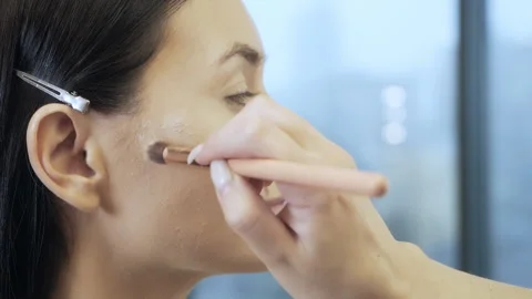 A professional make-up artist does makeup for a young girl. make-up artist Stock Footage 166062945