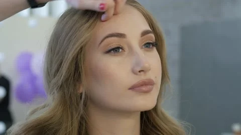 Professional make up artist doing make up for a beautiful caucasian model. Video stock 138936854