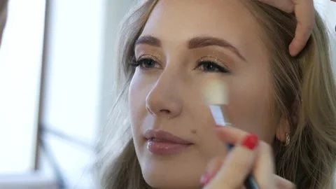 Professional make up artist doing make up for a beautiful caucasian model. Video stock 138937146