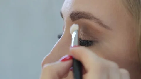 Professional make up artist doing make up for a beautiful caucasian model. Video stock 138937314