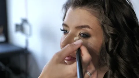 Professional make-up artist doing make-up to a young woman in a beauty salon Stock Footage 244922614