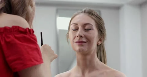 Professional make-up artist doing makeup of woman in beauty studio. Stock Footage 307574161