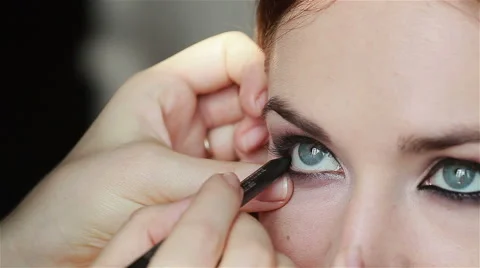 Professional make-up artist lining inner rim of the eye. Eyeliner make-up. Close Stock Footage 52993249