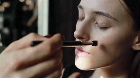 Professional make-up artist using brush to apply foundation to face of model Stock Footage 52266256