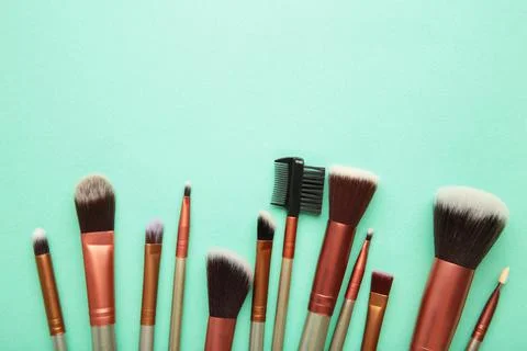 Professional make-up brushes on a mint background. Stock Photos