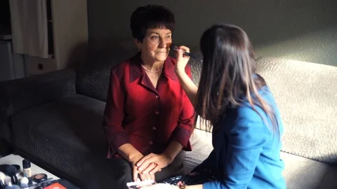 Professional make-up. Makeup artist doing makeup for an elderly woman Stock Footage 106378109