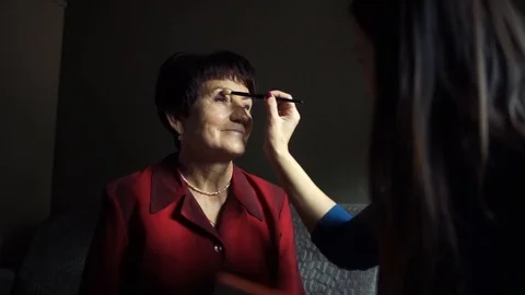 Professional make-up. Makeup artist doing makeup for an elderly woman Stock Footage 106379156
